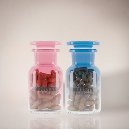 Two glass jars, one pink and one blue, filled with rest and repeat and pick me up on a light background.